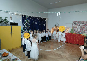 Na zdjęciu widzimy dzieci stojące w półkolu i mówiące wiersz.