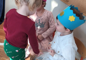 Dziewczynka składa życzenia i częstuje się wafelkiem.