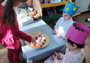 Dziewczynka częstuje się babeczką.