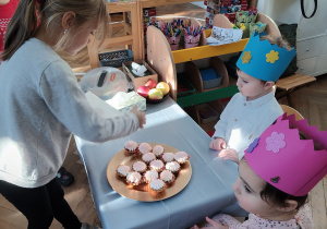 Dziewczynka częstuje się babeczką.