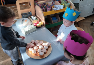 Chłopiec częstuje się babeczką.