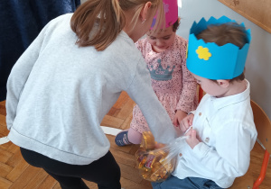 Dziewczynka składa życzenia i częstuje się wafelkiem.