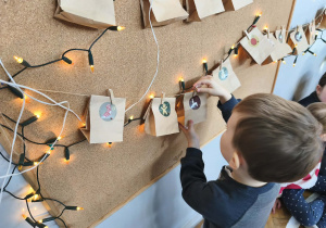 Na zdjęciu widzimy chłopca, który znalazł torebkę z kolejnym zadaniem z kalendarza adwentowego.