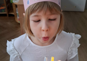 dziewczynka zdmuchuje świeczki