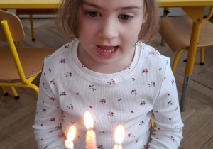 dziewczynka patrzy na symboliczny tort