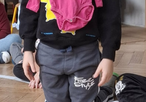 chłopiec przykłąda do tułowia różowe śpiochy