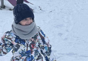 Zdjęcie przedstawia chłopca podczas zabaw na śniegu.
