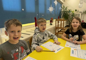 Zdjęcie przedstawia dzieci wykonujące ćwiczenie artykulacyjne.