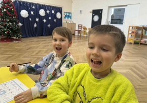 Zdjęcie przedstawia dzieci wykonujące ćwiczenie artykulacyjne.