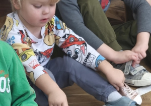 Chłopiec ogląda ubranka Hani