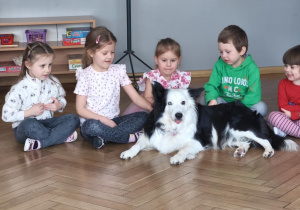 Pies leży koło siedzących dzieci