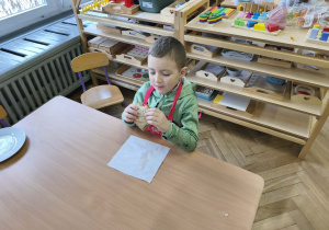 Na zdjęciu widzimy chłopca, który zjada tosta.