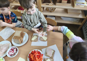 Na zdjęciu widzimy dzieci, które tworzą zdrowe tosty.