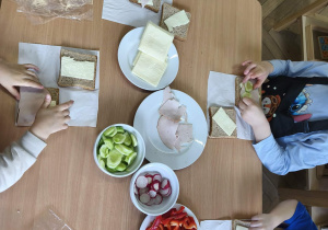 Na zdjęciu widzimy dzieci, które tworzą zdrowe tosty.