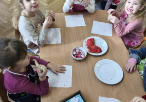 Na zdjęciu widzimy dzieci, które zjadają tosty.