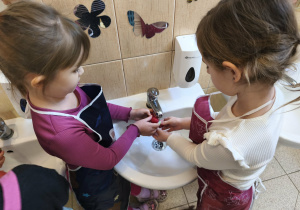 Na zdjęciu widzimy dziewczynki, które myją rzodkiewki.