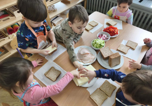 Na zdjęciu widzimy dzieci, które tworzą zdrowe tosty.