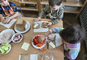 Na zdjęciu widzimy dzieci, które tworzą zdrowe tosty.