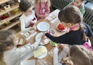 Na zdjęciu widzimy dzieci, które tworzą zdrowe tosty.