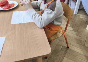 Na zdjęciu widzimy chłopca, który zjada tosta.