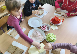 Na zdjęciu widzimy dzieci, które tworzą zdrowe tosty.