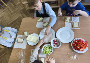 Na zdjęciu widzimy dzieci, które tworzą zdrowe tosty.