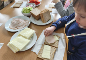 Na zdjęciu widzimy chłopca, który tworzą zdrowego tosta.