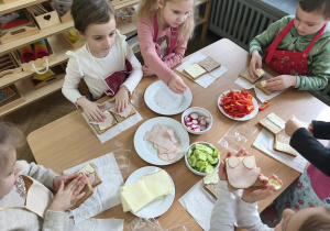 Na zdjęciu widzimy dzieci, które tworzą zdrowe tosty.Na zdjęciu widzimy dzieci, które tworzą zdrowe tosty.