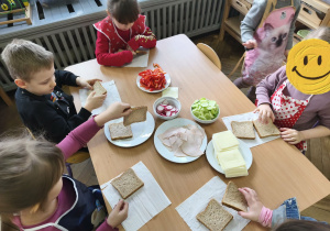Na zdjęciu widzimy dzieci, które tworzą zdrowe tosty.