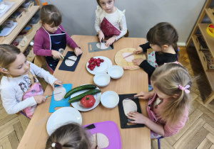 Na zdjęciu widzimy dzieci, które kroją wędlinę.