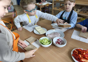 Na zdjęciu widzimy dzieci, które tworzą zdrowe tosty.