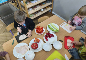 Na zdjęciu widzimy dzieci, które kroją szynkę.