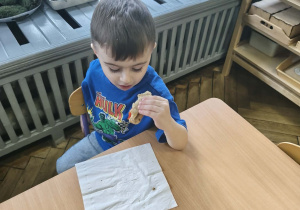 Na zdjęciu widzimy chłopca, który zjada tosta.