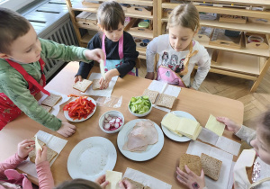 Na zdjęciu widzimy dzieci, które tworzą zdrowe tosty.