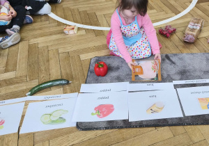 Na zdjęciu widzimy dziewczynkę, która przyporządkowuje wędlinę do ilustracji.