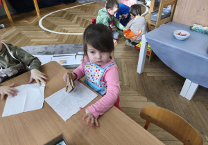 Na zdjęciu widzimy dziewczynkę, która zjada tosta.