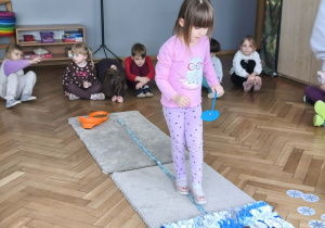 Na zdjęciu widzimy dziewczynkę, która wykonuje zadanie wskazane przez Panią Beatkę.