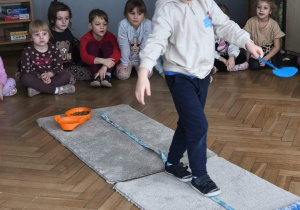 Na zdjęciu widzimy chłopca, który idzie noga za nogą po smyczy.