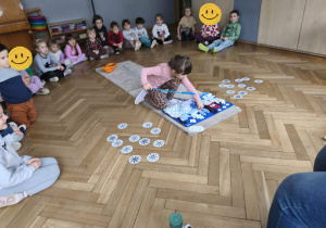 Na zdjęciu widzimy dziewczynkę, która chowa smaczka w macie węchowej.