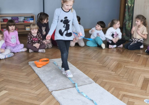 Na zdjęciu widzimy dziewczynkę, która wykonuje zadanie wskazane przez Panią Beatkę.