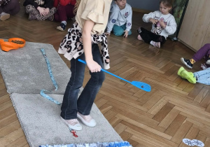 Na zdjęciu widzimy dziewczynkę, która będzie chować smaczka w macie węchowej.