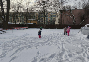 Na zdjęciu widzimy dzieci, które bawią się na śniegu.