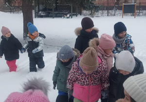 grupa dzieci która próbuje przejść po głębokim śniegu