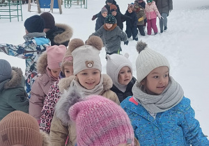 dzieci idące po głębokim śniegu. Uśmiech na twarzach - bezcenny