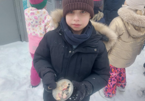 chłopiec, który pokazuje wykonaną przez siebie lodową bombkę