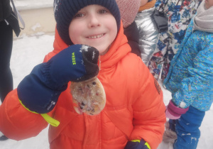 chłopiec, który pokazuje wykonaną przez siebie lodową bombkę