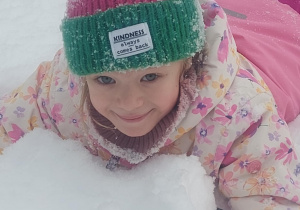 dziewczynka leżąca w śniegu