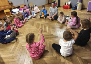 Nauczyciel siedzi w kręgu z dziećmi u ustala spanie