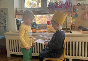 Zdjęcie przedstawia chłopca składającego życzenia Jubilatowi.