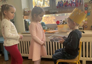 Zdjęcie przedstawia dziewczynkę składającą życzenia Jubilatowi.